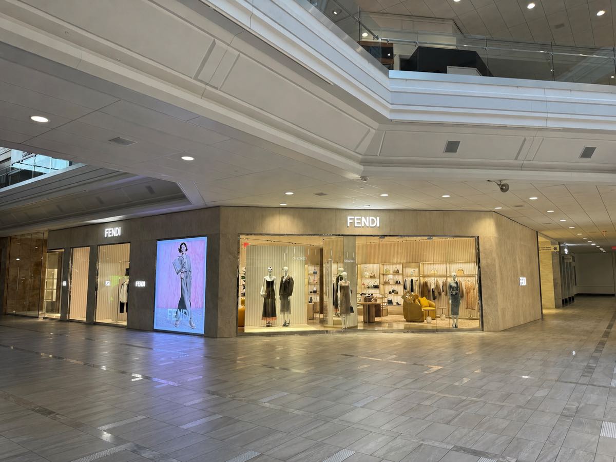The Fendi storefront at Copley Place in Boston, seen across the empty concourse, with smooth painted soffits and finished bulkheads framing the shop entrance.