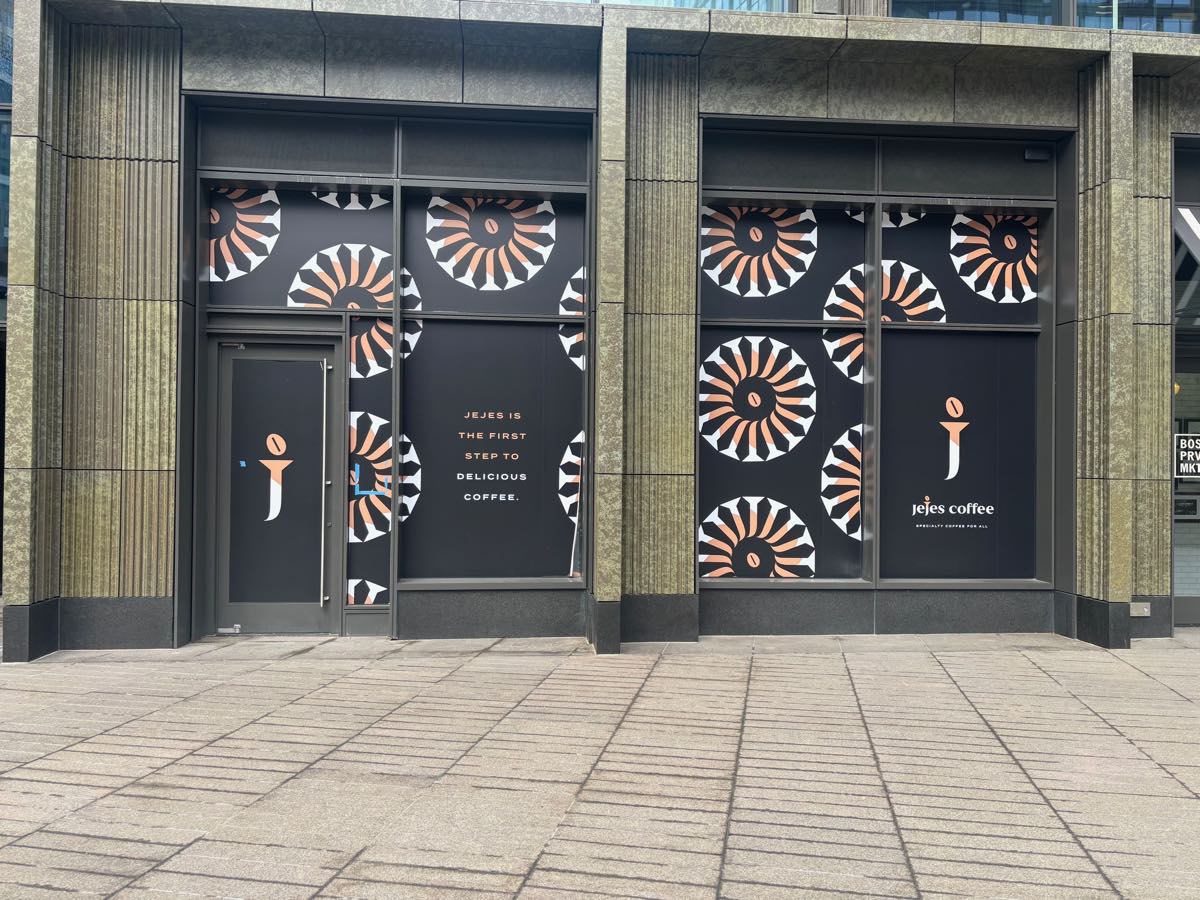 The Jeje's Coffee storefront in Boston's Seaport District, fitted out behind branded window graphics.